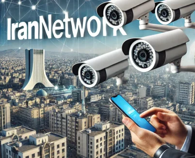 صویر حرفه‌ای از نصب دوربین مداربسته در محیط شهری با تمرکز بر تهران و نمایش برجسته متن "IranNetwork". پس‌زمینه شامل ساختمان‌ها و تجهیزات امنیتی است که سیستم‌های نظارتی برای امنیت کسب‌وکارها و منازل را نشان می‌دهد.
